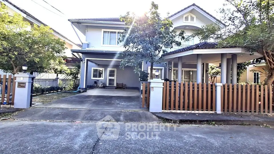 Charming two-story house with driveway and lush greenery in a serene neighborhood.