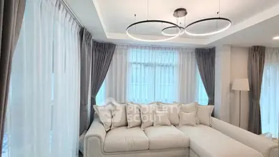 Luxurious living room with modern lighting and elegant curtains, featuring a plush sectional sofa.