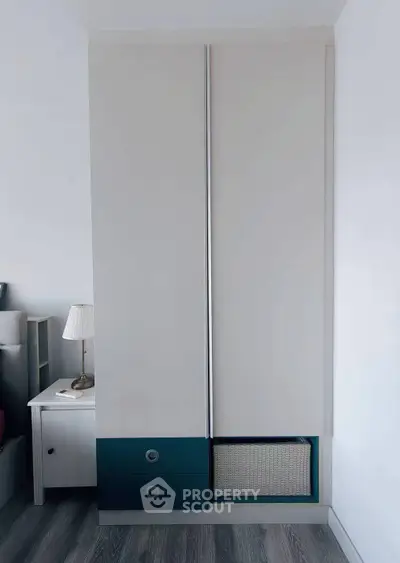 Modern bedroom with sleek wardrobe and stylish nightstand lamp.