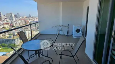 Spacious balcony with city view, outdoor seating, and washing machine in modern apartment.