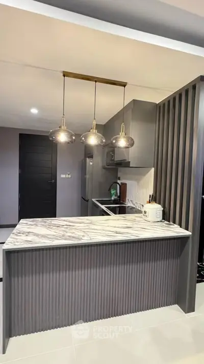 Modern kitchen with marble countertop and stylish pendant lights