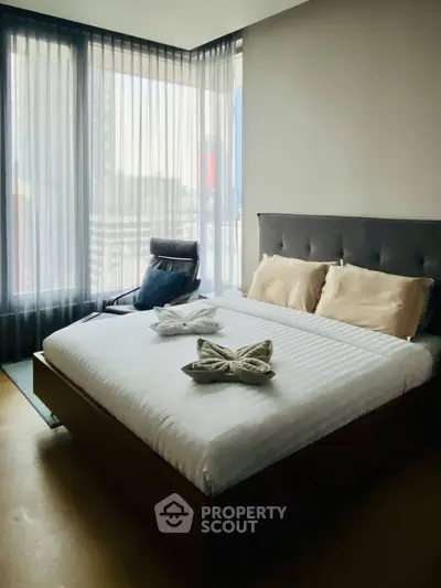 Modern bedroom with large windows and stylish decor in a high-rise apartment.