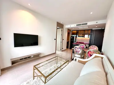 Modern living room with sleek furniture and open kitchen layout in luxury apartment.