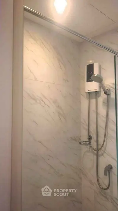 Modern bathroom with marble walls and sleek shower fixtures, perfect for a luxurious home.