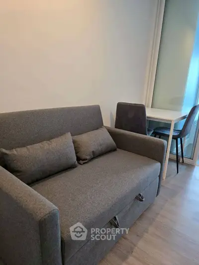 Cozy living room with modern gray sofa and dining area