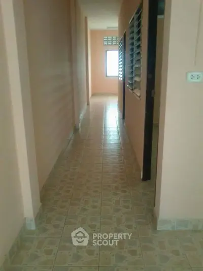 Spacious hallway with tiled flooring and natural light from window.