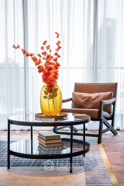 Elegant living room with modern decor, featuring a stylish chair and vibrant floral centerpiece.