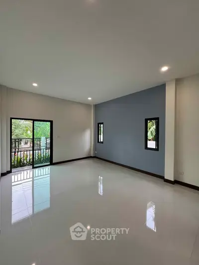 Spacious modern living room with large windows and balcony access