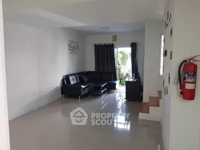 Spacious living room with modern black sofa and glossy tiled floor