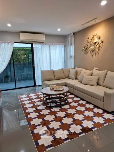 Stylish living room with modern decor, large sectional sofa, and geometric rug, perfect for relaxation and entertaining.