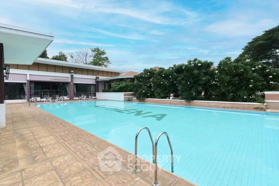 Luxurious outdoor pool area with lush greenery and modern design, perfect for relaxation and leisure.