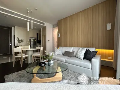 Chic modern apartment with an open layout connecting a cozy living room to an elegant kitchen, featuring sleek furniture and tasteful decor.