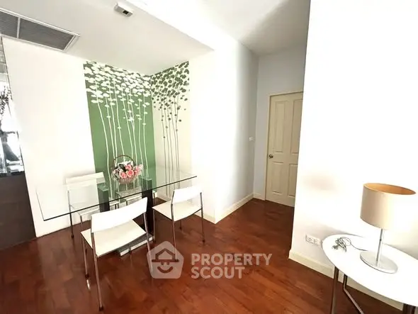 Modern dining area with glass table and stylish decor in a cozy apartment.
