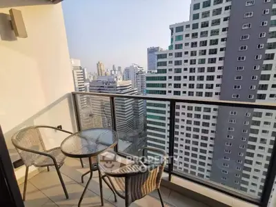 Stunning city view from modern high-rise balcony with outdoor seating.