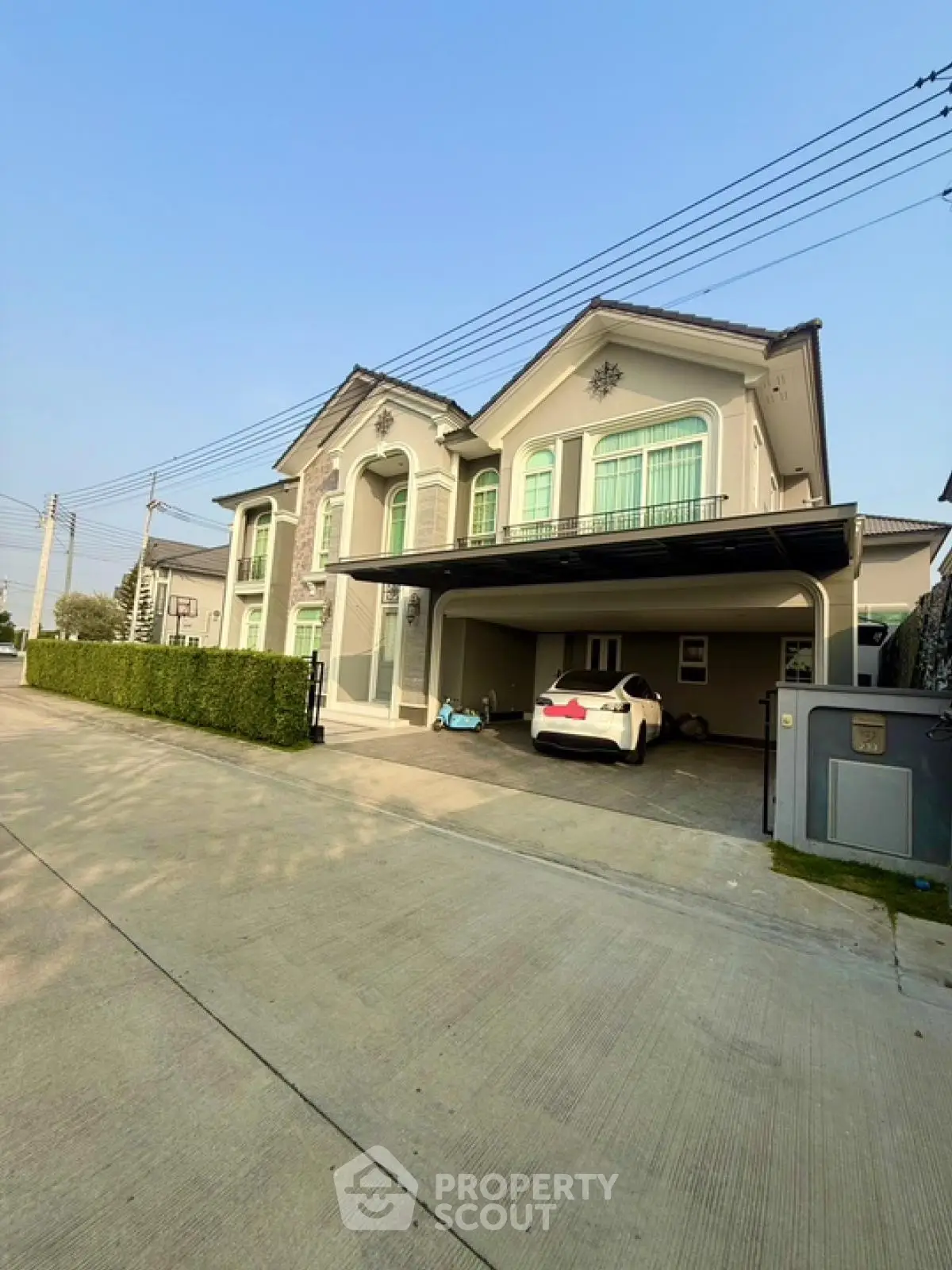 Luxurious modern house with spacious driveway and elegant facade in a serene neighborhood.
