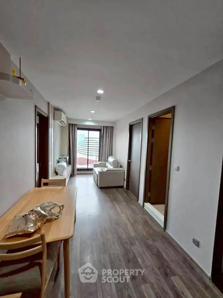 Modern apartment interior with open layout, featuring a cozy living area and stylish wooden flooring.