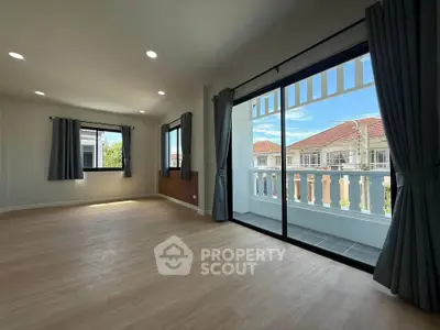 Spacious living room with large windows and balcony view in modern home