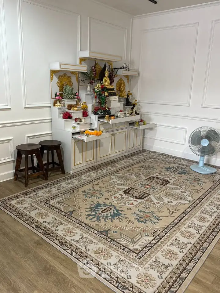Elegant interior with ornate rug and decorative altar in a serene living space.