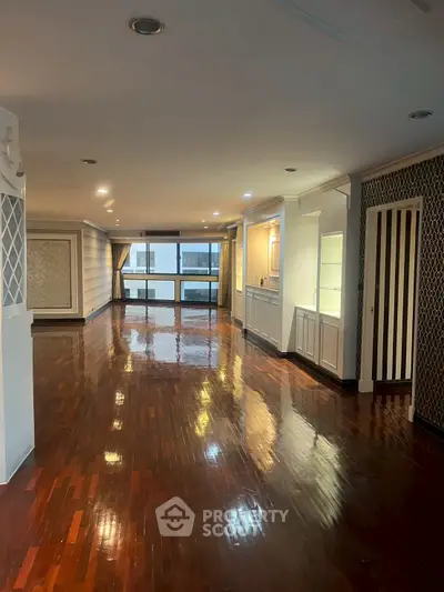 Spacious polished hardwood floor living room with elegant wall designs and ample natural light.