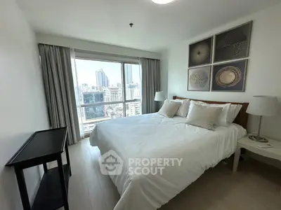 Modern bedroom with city view, featuring a cozy bed and elegant decor in a high-rise apartment.