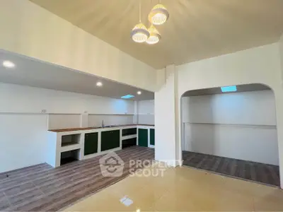 Spacious open-layout kitchen with modern lighting and ample storage space.