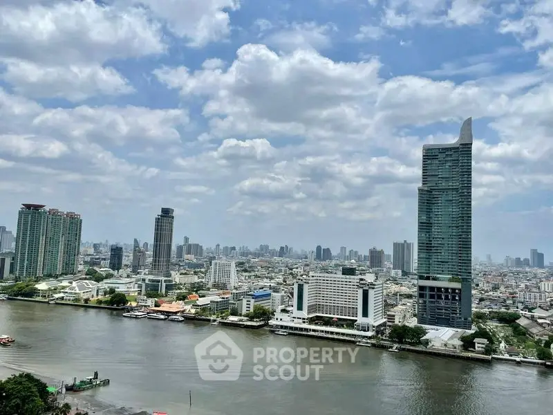 Stunning cityscape view with river and modern skyscrapers under a cloudy sky.