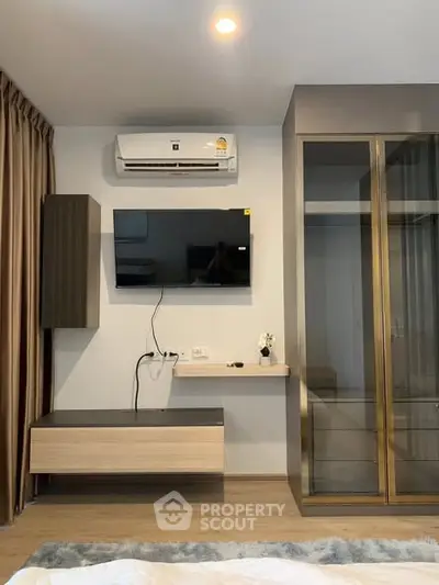 Modern bedroom with wall-mounted TV and air conditioning unit