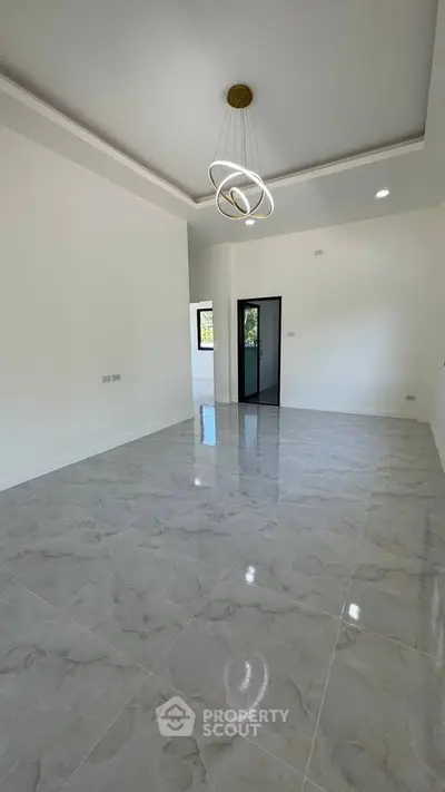 Spacious modern living room with elegant lighting and glossy tiled floors