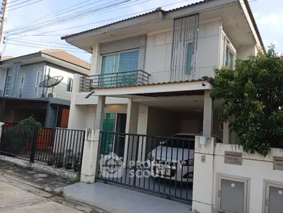 Modern two-story house with carport and gated entrance in suburban neighborhood