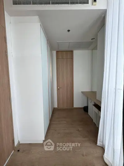 Modern minimalist interior with wooden flooring and built-in storage