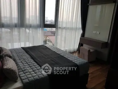 Modern bedroom with large windows and stylish decor in a high-rise apartment.