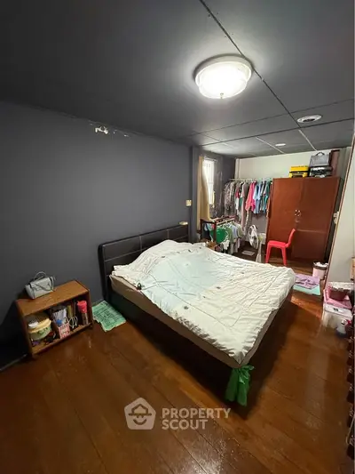 Cozy bedroom with wooden flooring and ample storage space