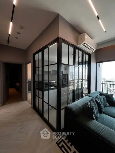 Modern living room with glass-enclosed kitchen and sleek air conditioning unit.