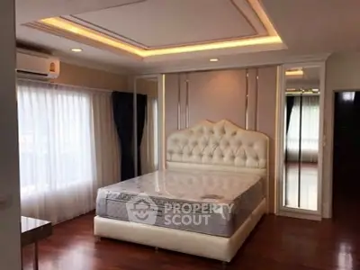 Luxurious bedroom with elegant design and large windows offering natural light.