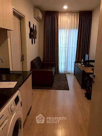 Cozy living room with modern decor and washing machine in a compact apartment.
