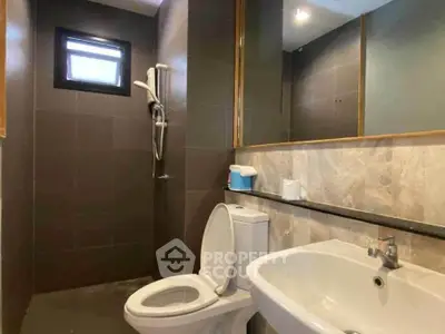 Modern bathroom with sleek fixtures and a minimalist design, featuring a shower and a large mirror.