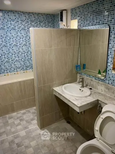 Modern bathroom with tiled walls and built-in bathtub