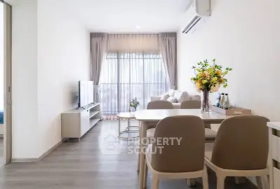 Modern living room with elegant decor and natural light, featuring a cozy dining area and stylish furniture.
