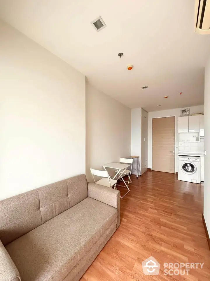 Modern living room with compact dining area and in-unit laundry