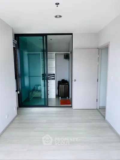 Spacious modern bedroom with walk-in closet and sleek sliding glass doors