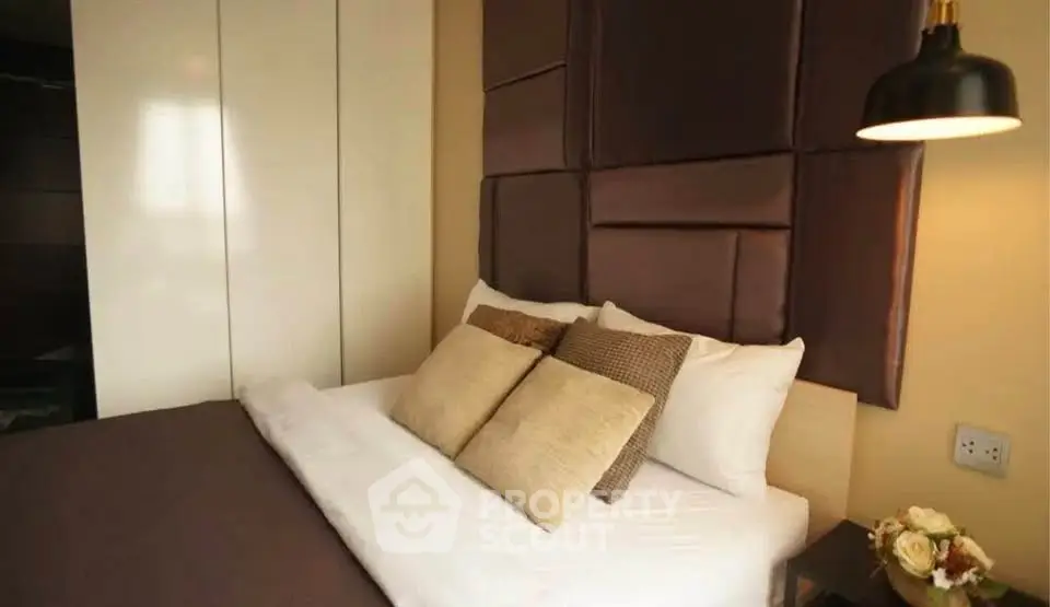 Cozy bedroom with elegant padded headboard and soft lighting, perfect for relaxation.