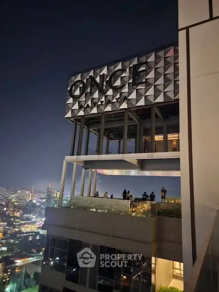 Stunning night view of a modern high-rise building with cityscape backdrop.