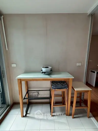 Compact kitchen area with wooden table and stools, perfect for small spaces.