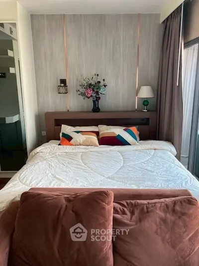 Cozy bedroom with stylish decor and large window offering natural light