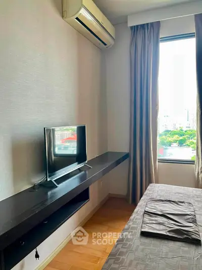Modern bedroom with air conditioning and large window offering city view