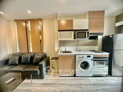Modern living room with integrated kitchen featuring washing machine and microwave
