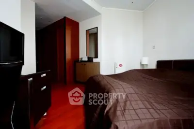 Cozy bedroom with modern furnishings and warm wooden flooring, perfect for relaxation and comfort.