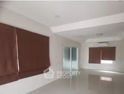 Spacious empty living room with large windows and modern design.