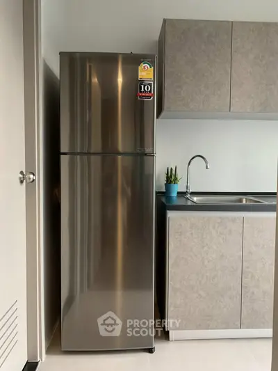 Modern kitchen with sleek stainless steel fridge and minimalist cabinetry