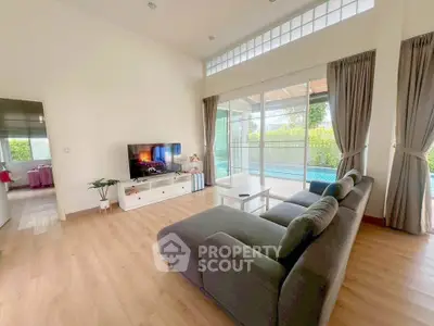 Spacious living room with pool view and modern decor in a luxury home.